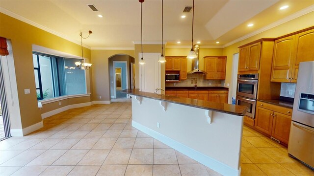 kitchen featuring light tile patterned floors, appliances with stainless steel finishes, pendant lighting, and a kitchen bar