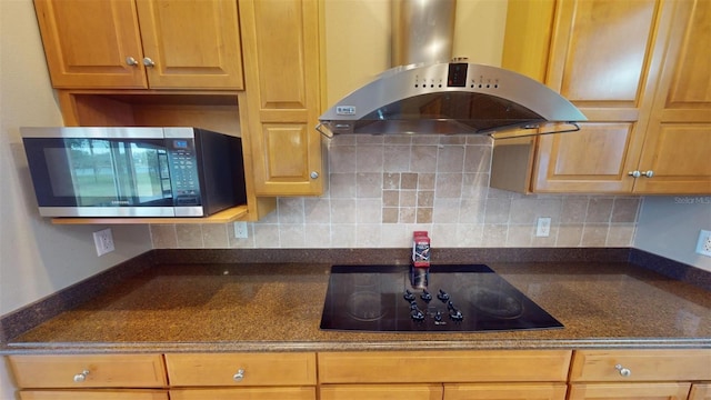 kitchen with dark stone countertops, black electric cooktop, island range hood, and tasteful backsplash