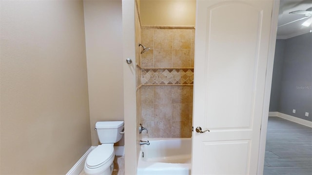 bathroom featuring toilet, tiled shower / bath combo, wood-type flooring, and ornamental molding