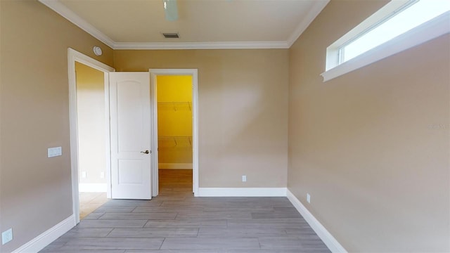 empty room with light wood-type flooring and crown molding