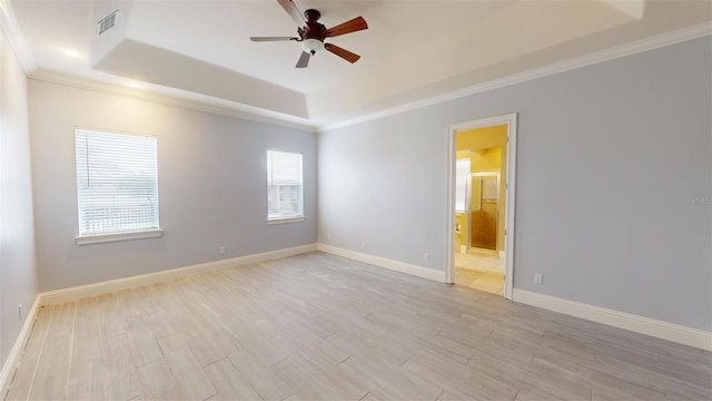 spare room featuring ceiling fan, a tray ceiling, and crown molding