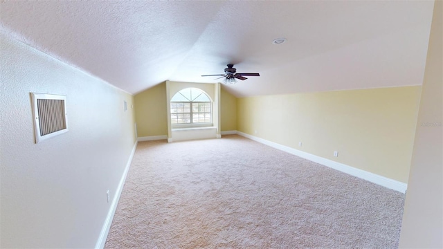 bonus room with a textured ceiling, ceiling fan, lofted ceiling, and light colored carpet