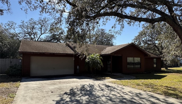 ranch-style house with a garage, fence, concrete driveway, roof with shingles, and a front yard