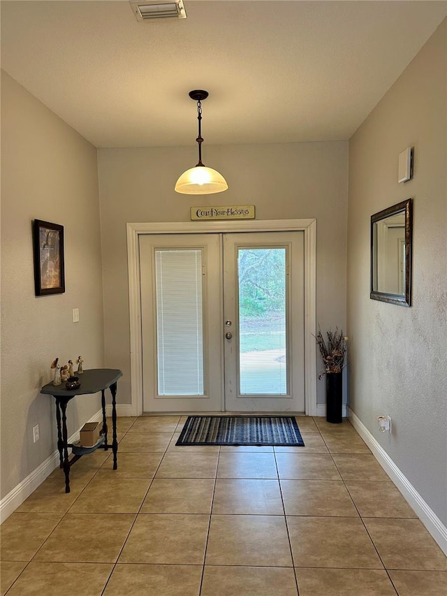 entrance foyer with light tile patterned floors and french doors