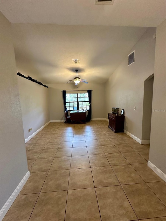 empty room with ceiling fan and light tile patterned floors