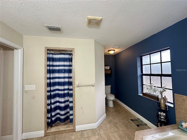 bathroom with toilet, a shower with shower curtain, tile patterned flooring, and a textured ceiling