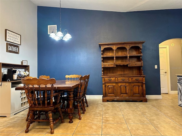 dining space with light tile patterned flooring and an inviting chandelier