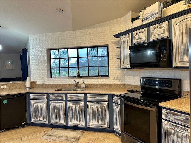 kitchen featuring black appliances, light tile patterned floors, vaulted ceiling, and sink