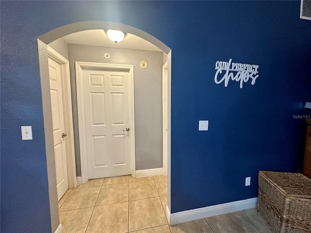 hall featuring light tile patterned flooring