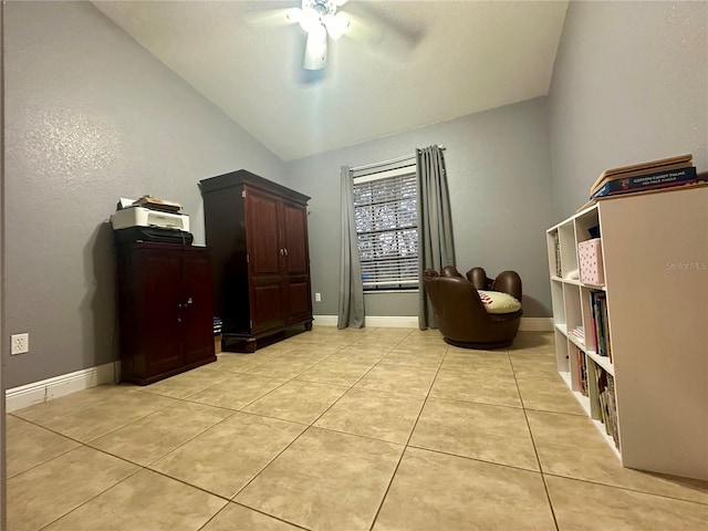 living area featuring lofted ceiling, ceiling fan, and light tile patterned flooring