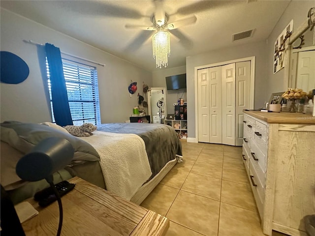 tiled bedroom with ceiling fan and a closet