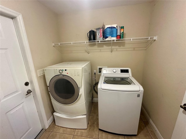 laundry area featuring light tile patterned floors and separate washer and dryer