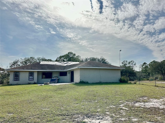 rear view of property featuring a lawn and a patio