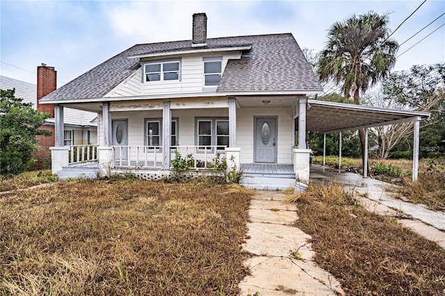 view of front of home with covered porch and a carport