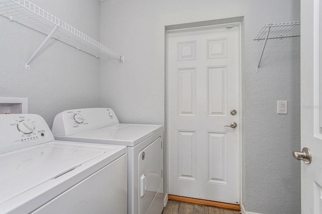 laundry room with wood-type flooring and washer and dryer