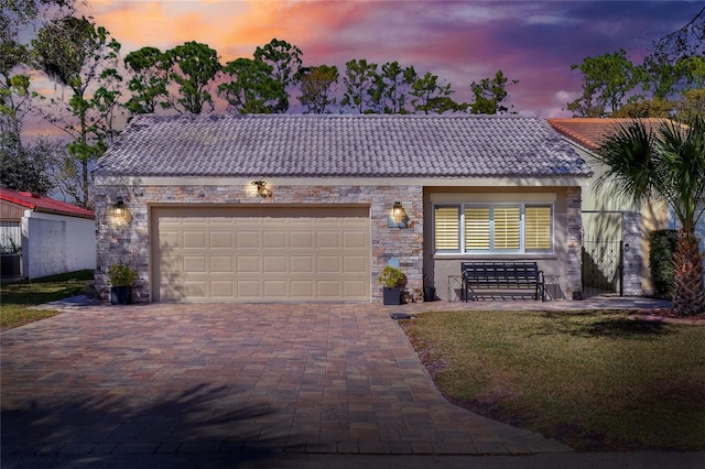 view of front of house featuring cooling unit, a garage, and a lawn