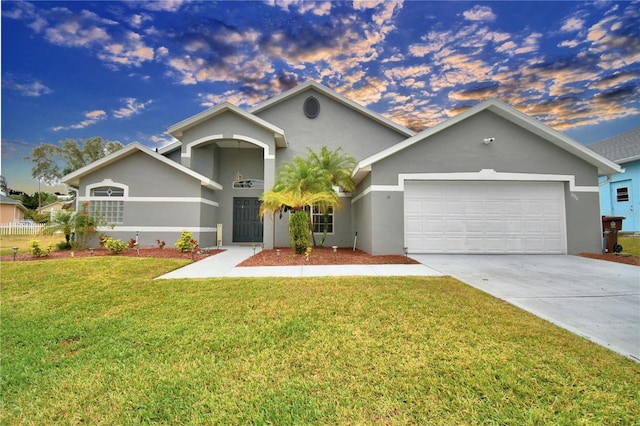 ranch-style home with a garage and a yard