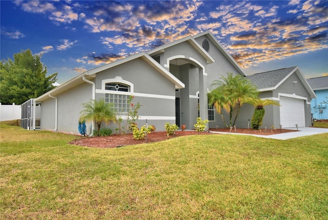 view of front of home with a garage and a yard