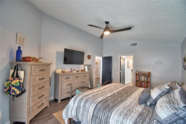 bedroom with lofted ceiling, ensuite bath, ceiling fan, a textured ceiling, and dark hardwood / wood-style flooring