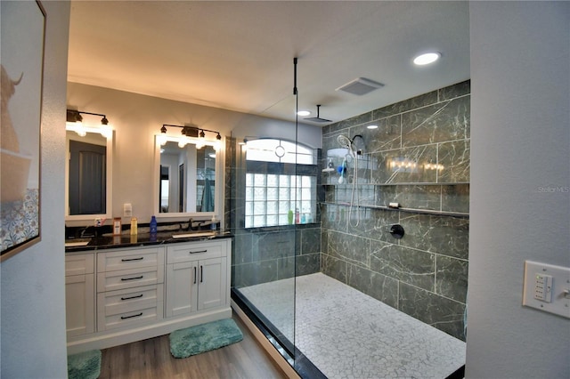 bathroom featuring vanity, hardwood / wood-style floors, and a tile shower