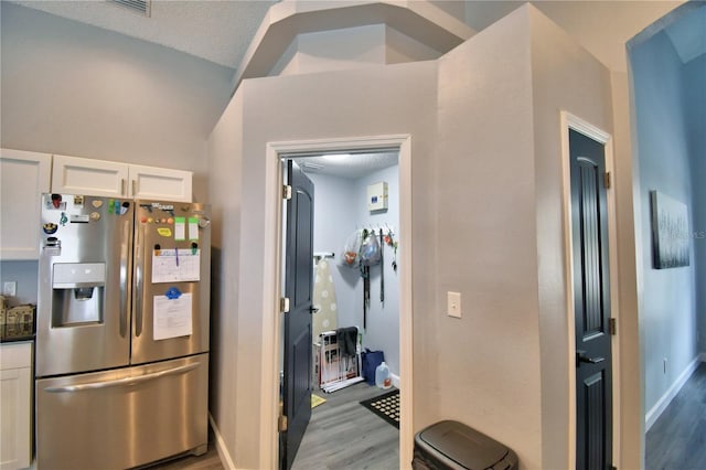 kitchen featuring white cabinetry, stainless steel fridge, dark hardwood / wood-style flooring, and a textured ceiling