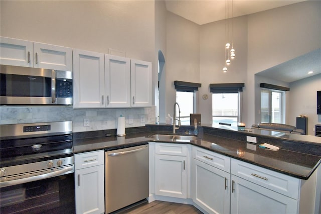 kitchen with stainless steel appliances, white cabinetry, and sink