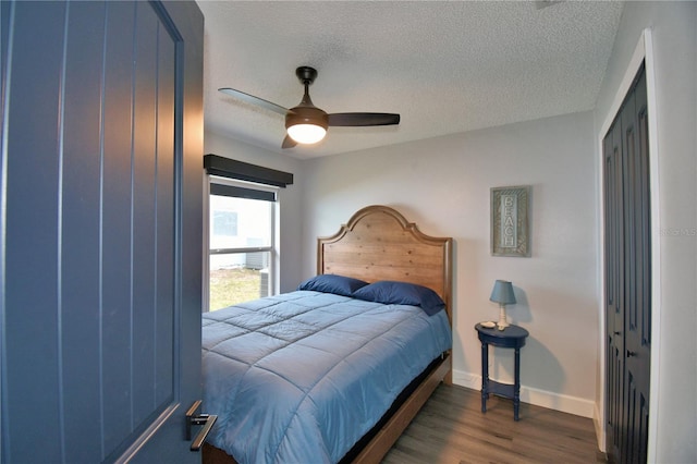 bedroom featuring dark hardwood / wood-style flooring, a textured ceiling, a closet, and ceiling fan