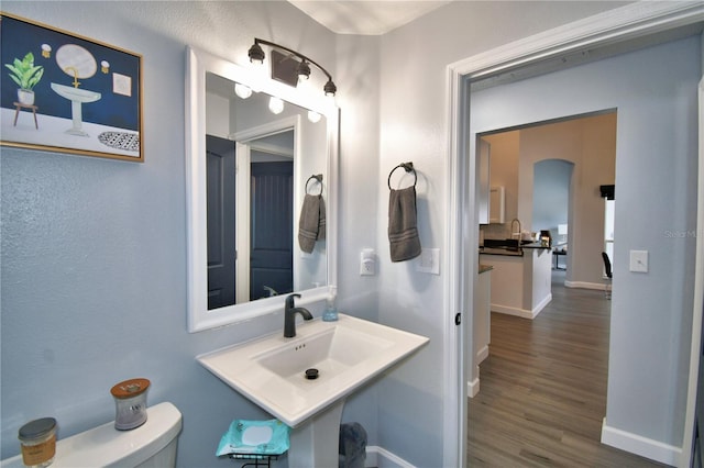 bathroom featuring hardwood / wood-style flooring, sink, and toilet