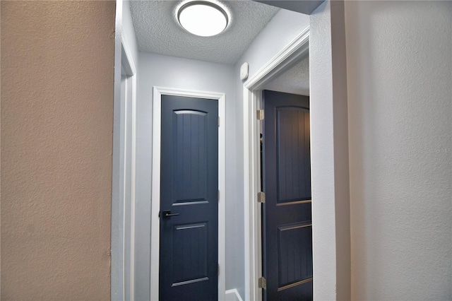 hallway with a textured ceiling