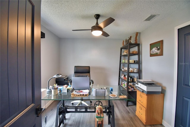 office area featuring a textured ceiling, ceiling fan, and light hardwood / wood-style flooring