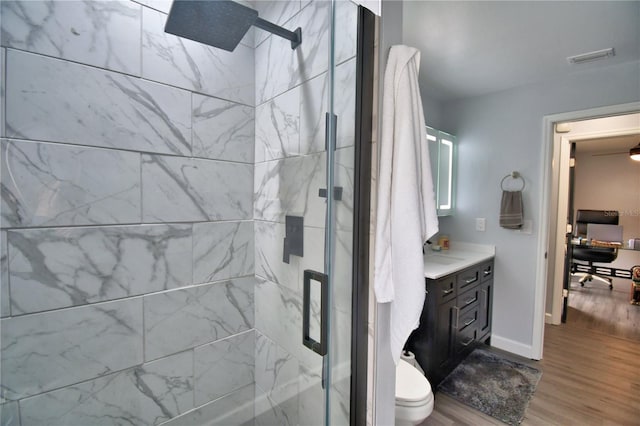 bathroom with a shower with door, wood-type flooring, vanity, and toilet