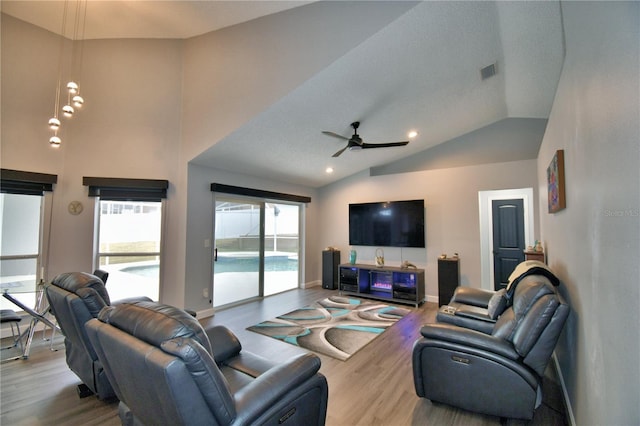 living room with hardwood / wood-style floors, vaulted ceiling, and ceiling fan