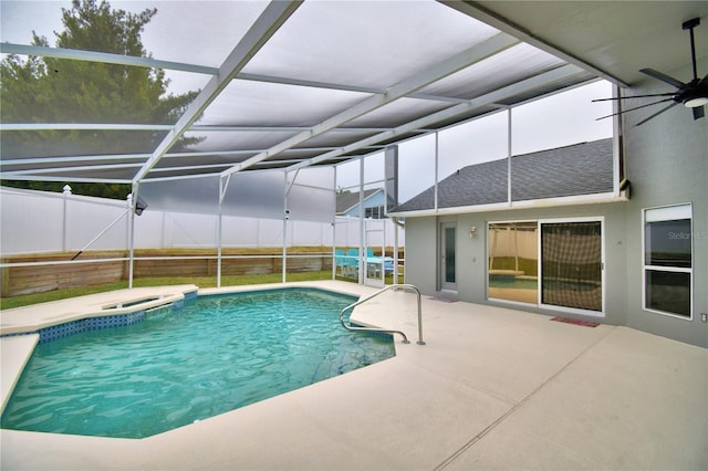 view of pool with a hot tub, a patio area, and glass enclosure