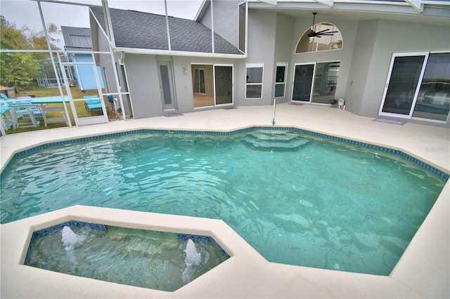 view of pool with ceiling fan, a patio area, and glass enclosure