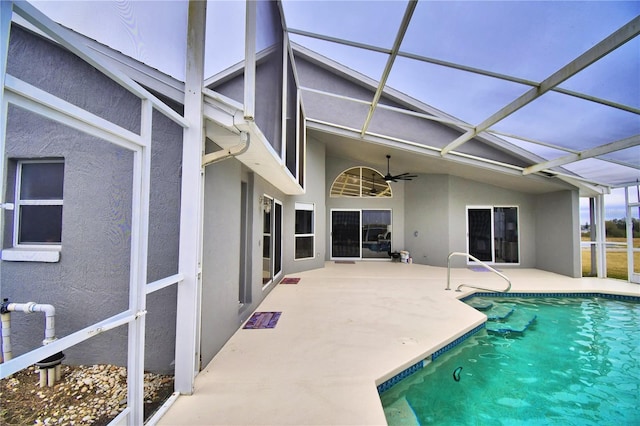 view of swimming pool with ceiling fan, a lanai, and a patio area