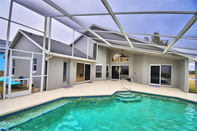 view of swimming pool featuring ceiling fan, a patio area, and glass enclosure