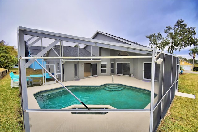 view of swimming pool featuring a patio area, a lawn, and glass enclosure