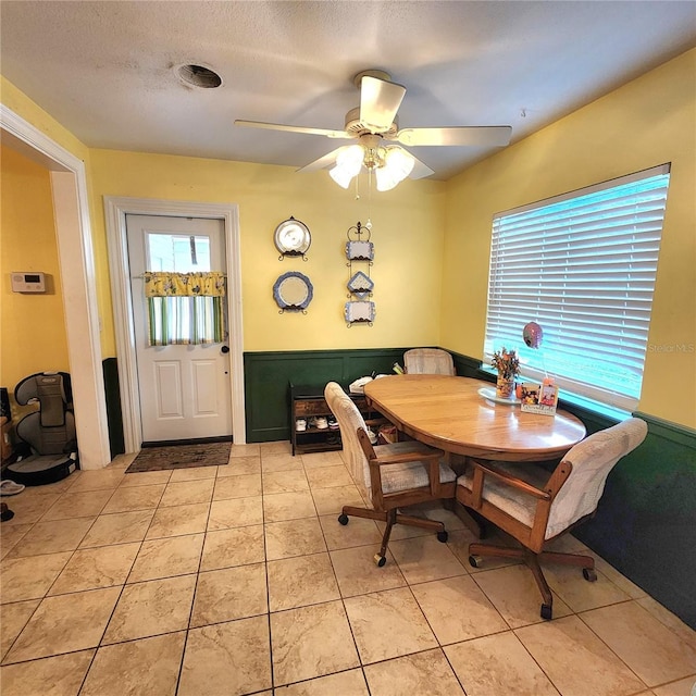 tiled dining room featuring ceiling fan and a textured ceiling