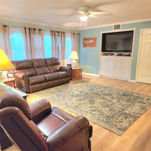 living room with ceiling fan, ornamental molding, and light wood-type flooring