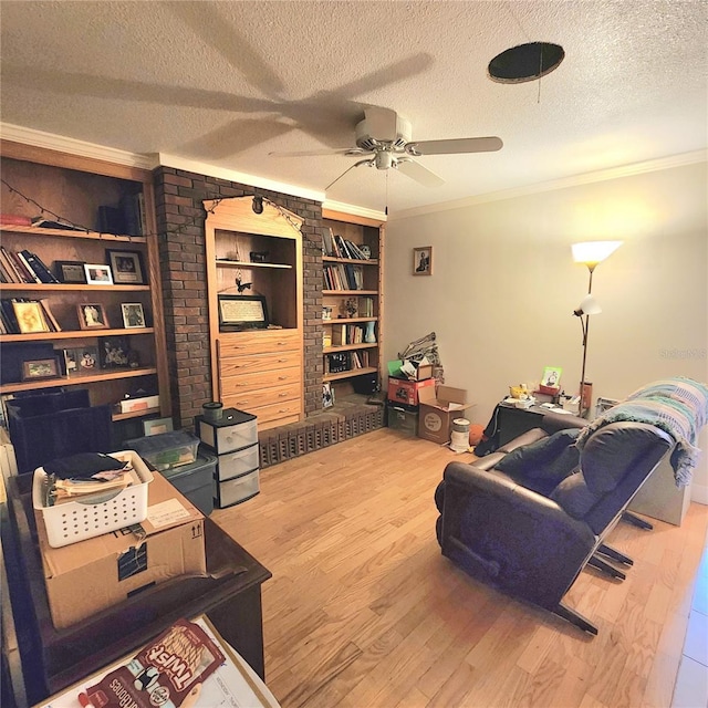 living room featuring hardwood / wood-style floors, crown molding, built in features, and a textured ceiling