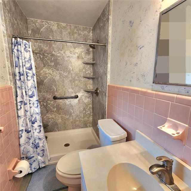 bathroom with vanity, tile walls, a shower with shower curtain, and toilet