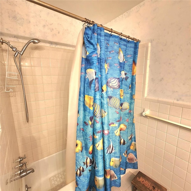 bathroom with tile walls and shower / tub combo