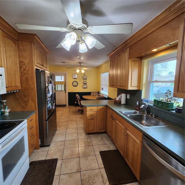 kitchen with light tile patterned flooring, sink, ceiling fan, kitchen peninsula, and white appliances