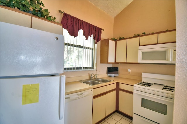 kitchen featuring lofted ceiling, sink, light tile patterned floors, white appliances, and a textured ceiling