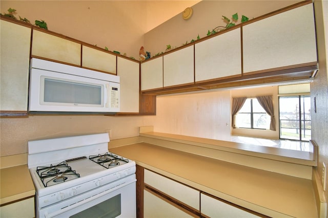 kitchen featuring white cabinets and white appliances