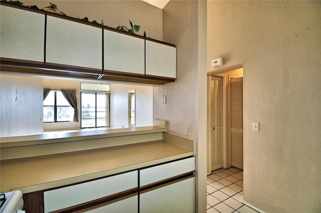 kitchen featuring light tile patterned floors and white cabinets