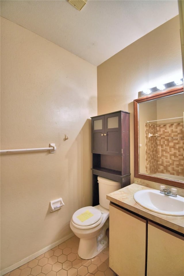 bathroom with tile patterned flooring, vanity, and toilet