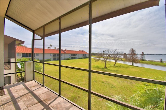 unfurnished sunroom featuring a water view