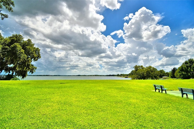 surrounding community featuring a water view and a yard