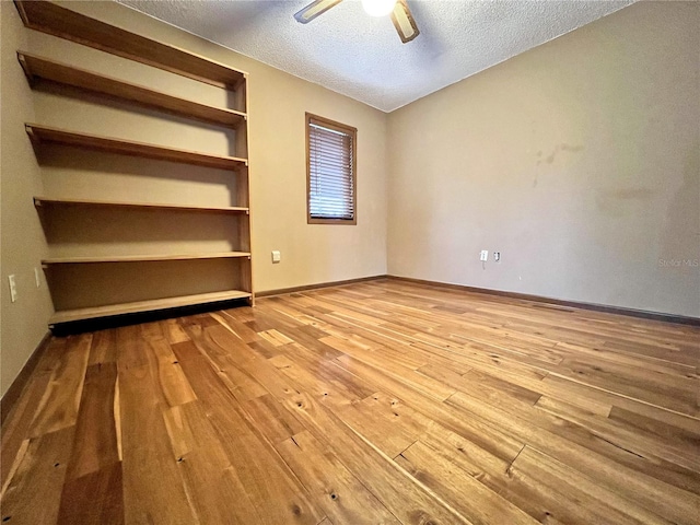 unfurnished bedroom with ceiling fan, wood-type flooring, and a textured ceiling